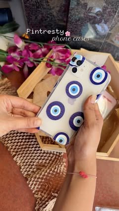 Clear evil eye case held over a wooden tray with flowers